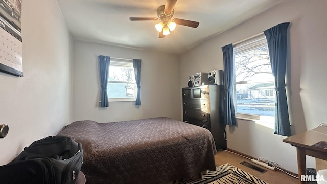 bedroom with ceiling fan, multiple windows, and carpet floors