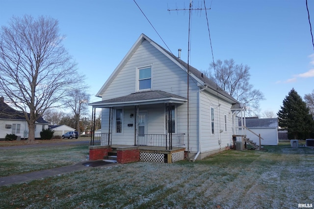 bungalow featuring covered porch and a front yard