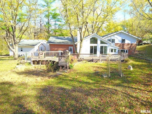 rear view of property featuring a yard and a wooden deck