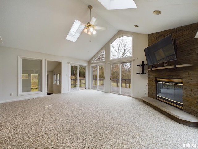 unfurnished living room featuring carpet flooring, high vaulted ceiling, a stone fireplace, and ceiling fan