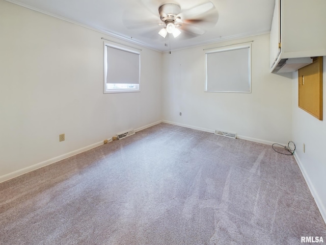 carpeted spare room featuring ceiling fan and ornamental molding