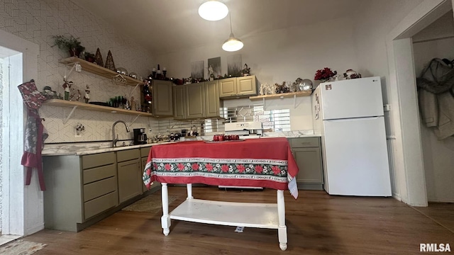 kitchen with tasteful backsplash, lofted ceiling, hanging light fixtures, and white fridge