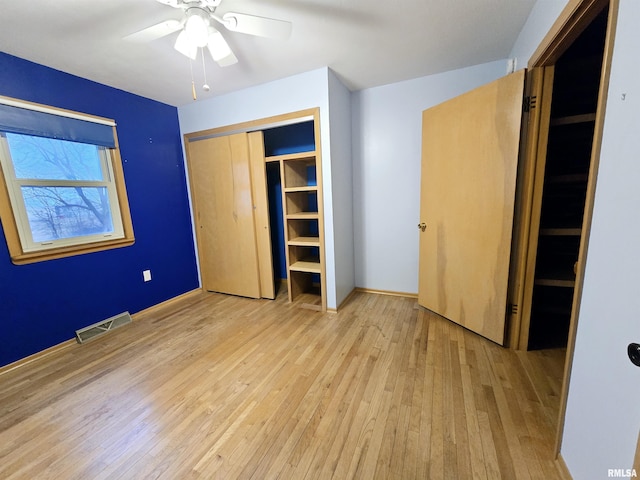 unfurnished bedroom with light hardwood / wood-style flooring, a closet, and ceiling fan