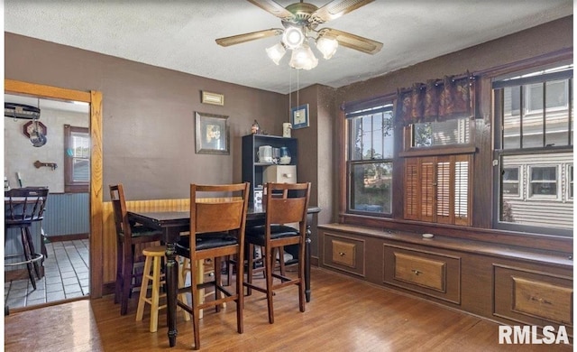 dining room with ceiling fan, a textured ceiling, and hardwood / wood-style flooring