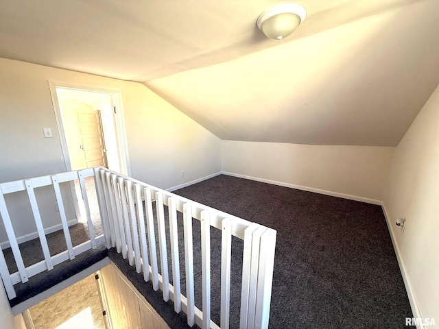 staircase featuring carpet and vaulted ceiling