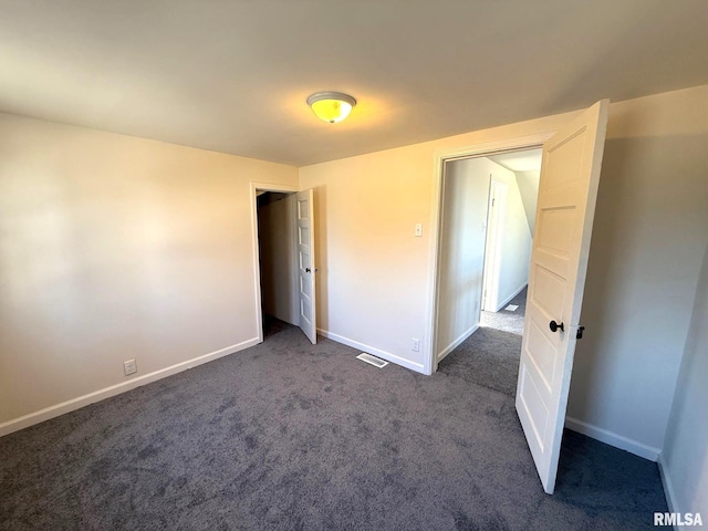 unfurnished bedroom with dark colored carpet