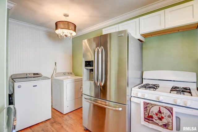 washroom with light hardwood / wood-style floors, washing machine and clothes dryer, crown molding, and an inviting chandelier