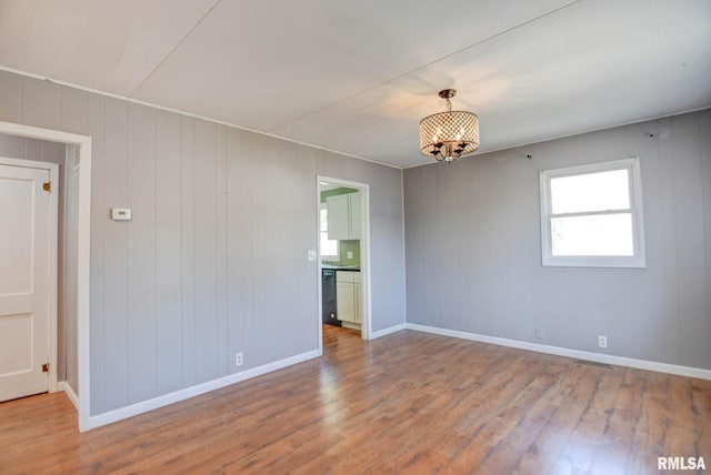 unfurnished room featuring hardwood / wood-style floors and wooden walls