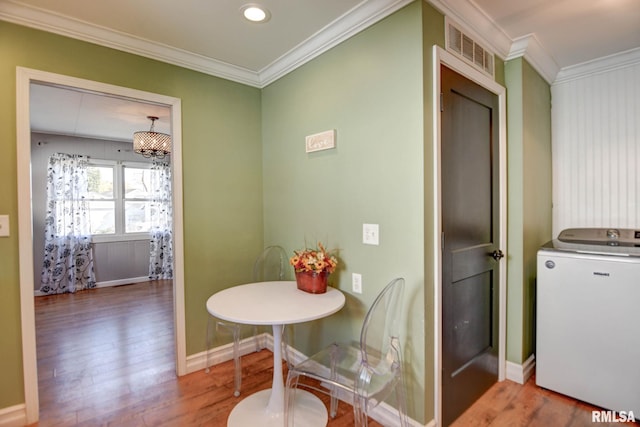 dining room with hardwood / wood-style flooring and crown molding