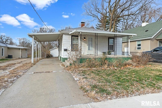 bungalow-style house featuring covered porch, a carport, and central air condition unit