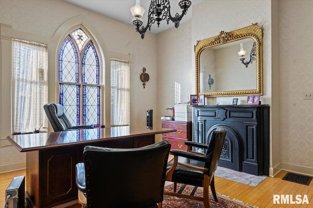 office area with an inviting chandelier and hardwood / wood-style flooring