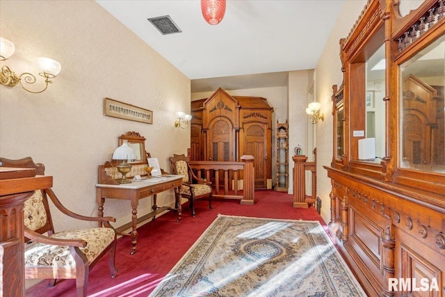 sitting room featuring dark colored carpet