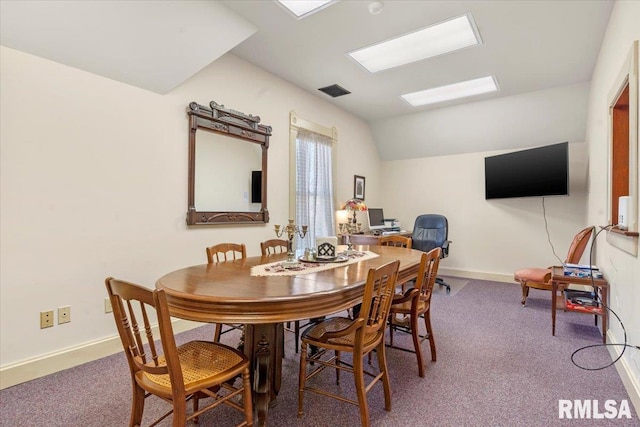 carpeted dining room with lofted ceiling