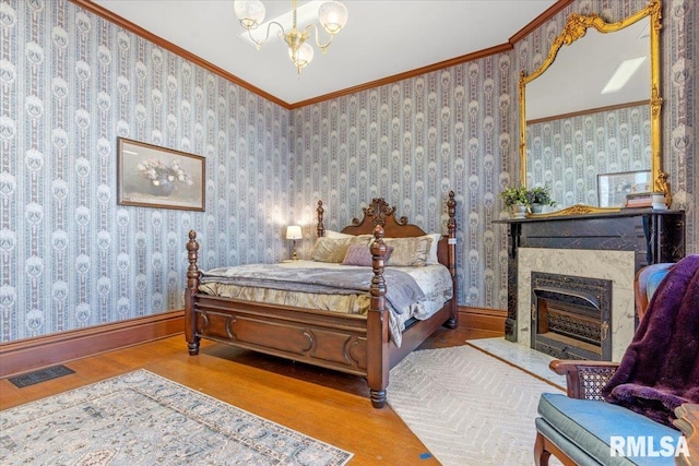 bedroom featuring a notable chandelier, wood-type flooring, and ornamental molding