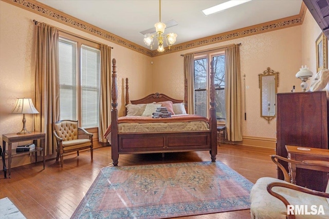 bedroom with wood-type flooring and a notable chandelier