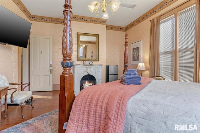 bedroom with hardwood / wood-style floors, a chandelier, and ornamental molding