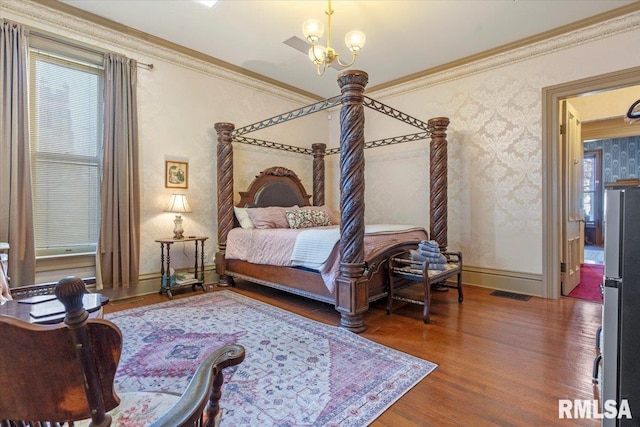 bedroom with stainless steel refrigerator, crown molding, a chandelier, and dark hardwood / wood-style floors