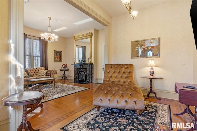 sitting room featuring an inviting chandelier and hardwood / wood-style flooring