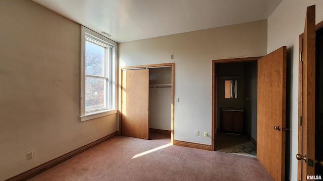 unfurnished bedroom with a closet and light colored carpet