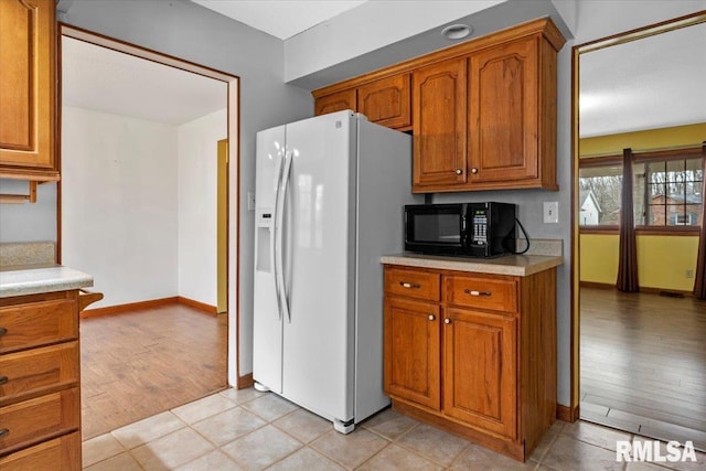 kitchen featuring white fridge with ice dispenser and light wood-type flooring