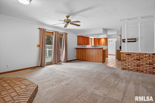 unfurnished living room featuring ceiling fan, ornamental molding, a textured ceiling, and light carpet