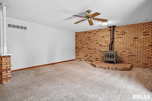 unfurnished living room with carpet flooring, crown molding, brick wall, and a textured ceiling