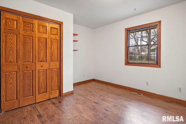 unfurnished bedroom featuring a textured ceiling and hardwood / wood-style flooring