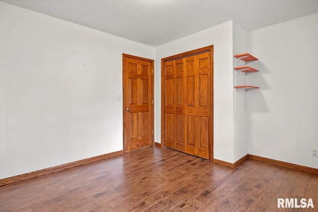 unfurnished bedroom with a closet, wood-type flooring, and a textured ceiling