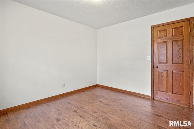 empty room featuring a textured ceiling and hardwood / wood-style flooring