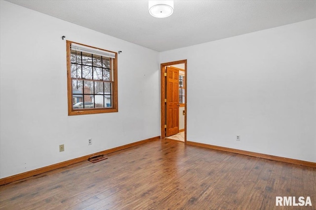 spare room with wood-type flooring and a textured ceiling