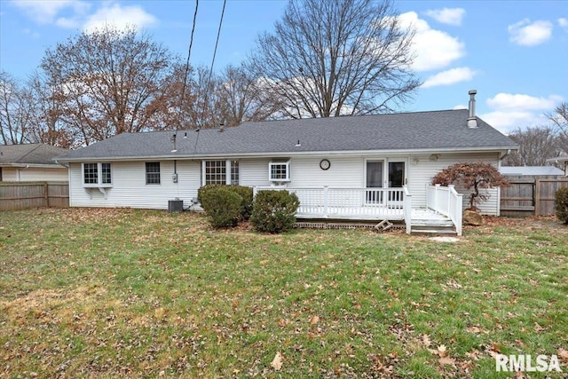 back of property featuring a lawn, a deck, and central AC