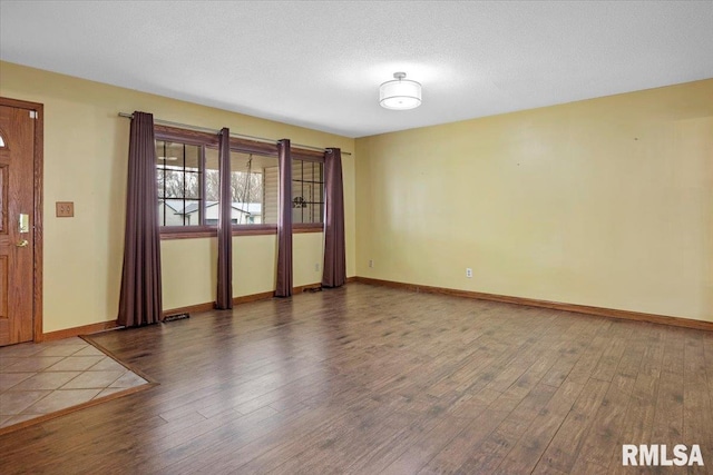 empty room featuring hardwood / wood-style flooring and a textured ceiling