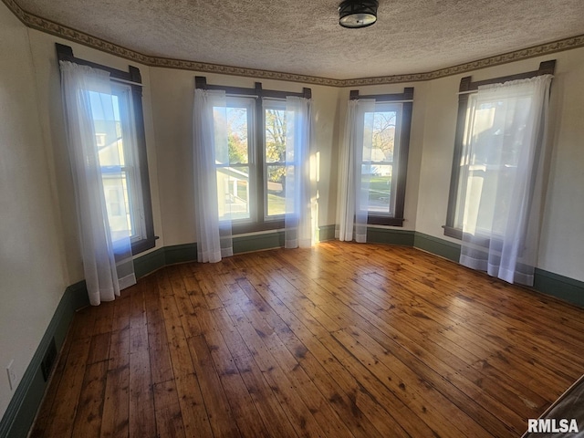 unfurnished room featuring hardwood / wood-style floors and a textured ceiling