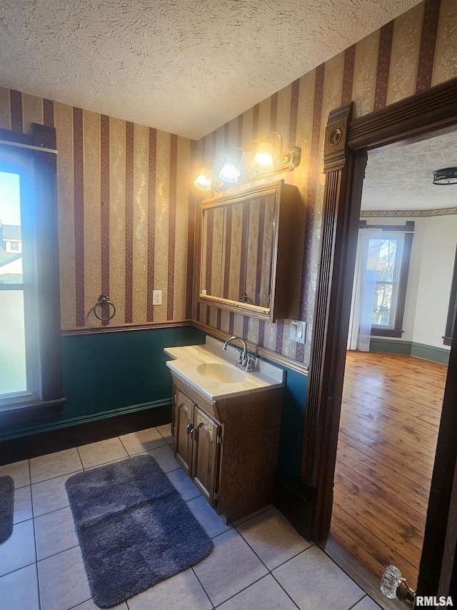 bathroom with tile patterned floors, vanity, and a textured ceiling