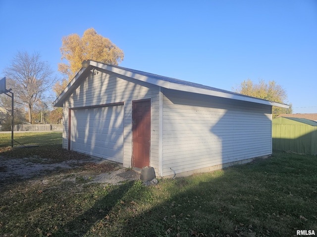 exterior space with a lawn, a garage, and an outdoor structure