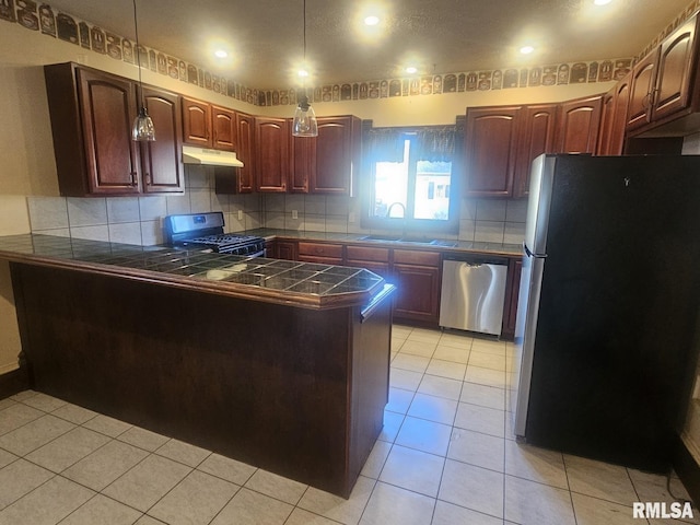 kitchen with sink, backsplash, kitchen peninsula, light tile patterned flooring, and appliances with stainless steel finishes