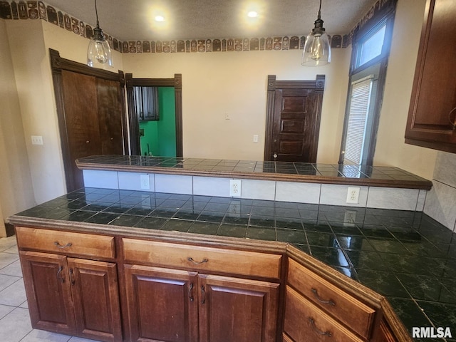 kitchen with kitchen peninsula, light tile patterned floors, and hanging light fixtures