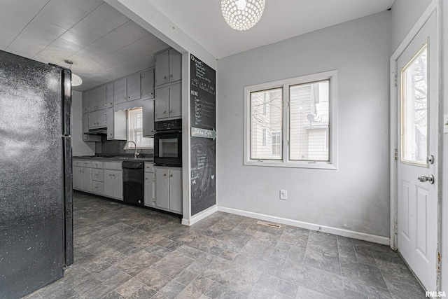 kitchen featuring black appliances, a healthy amount of sunlight, and gray cabinets