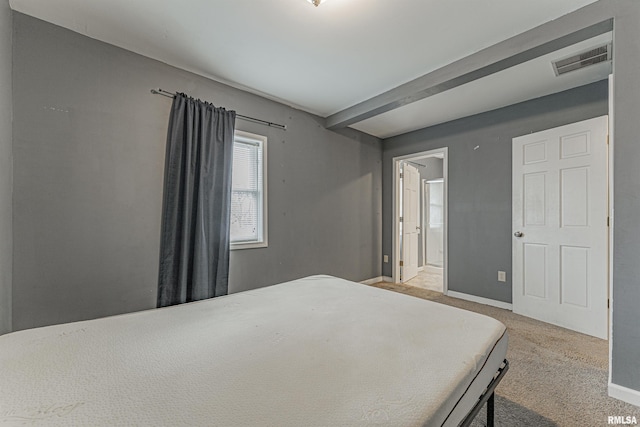 bedroom featuring light carpet and connected bathroom