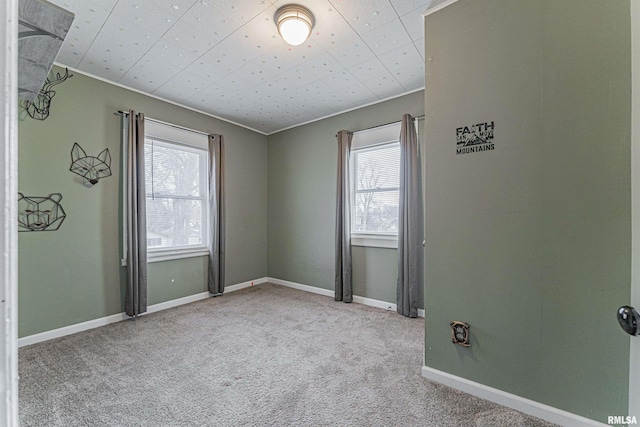 carpeted empty room featuring ornamental molding and a healthy amount of sunlight