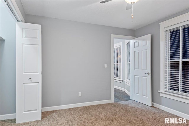 unfurnished bedroom featuring ceiling fan and carpet