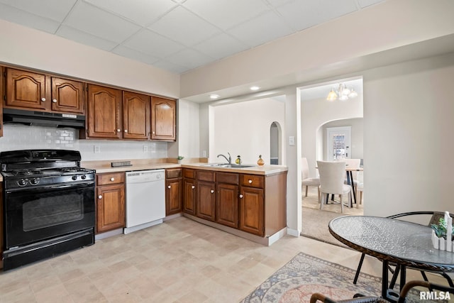 kitchen with a paneled ceiling, white dishwasher, decorative backsplash, black gas range oven, and a notable chandelier