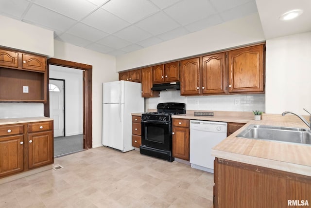 kitchen featuring tasteful backsplash, a paneled ceiling, sink, and white appliances