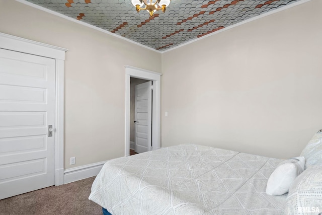 carpeted bedroom featuring ornamental molding and a notable chandelier