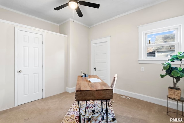 home office featuring ceiling fan, ornamental molding, and light carpet