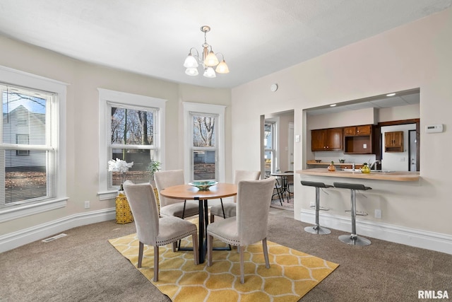 carpeted dining space with a notable chandelier