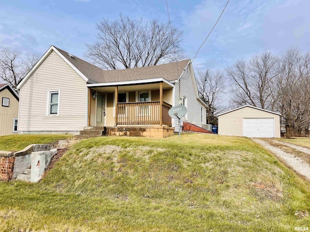 view of front facade with a garage, a porch, an outbuilding, and a front lawn