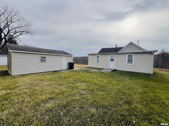 back of property featuring an outbuilding and a yard