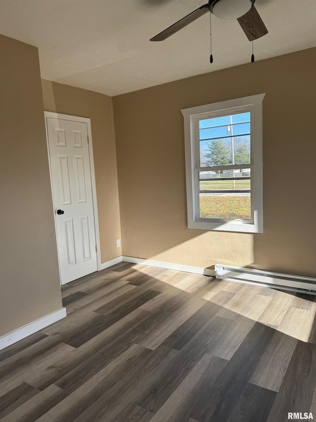 spare room with a textured ceiling, ceiling fan, and dark wood-type flooring