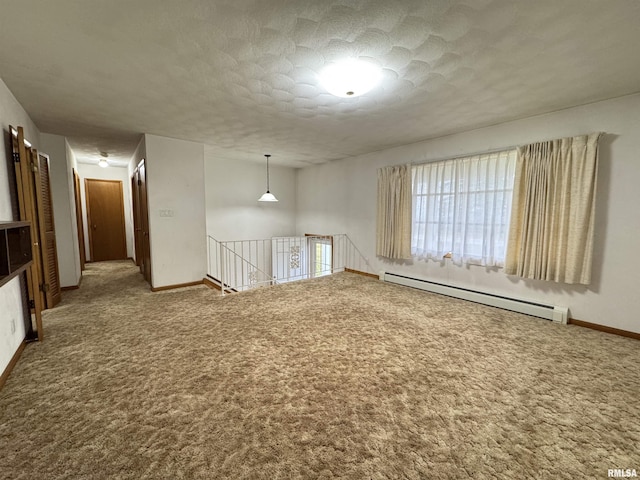 empty room featuring carpet flooring, a baseboard radiator, and a textured ceiling